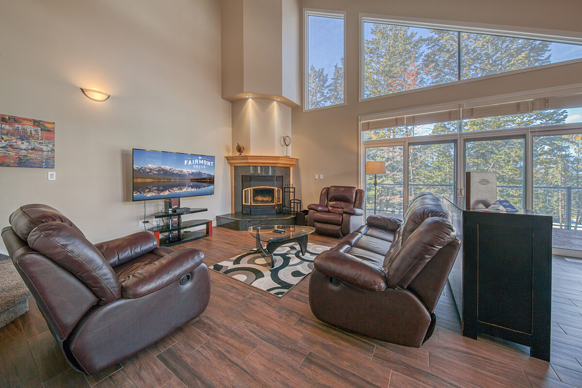 Living space with leather chairs, rug, and television.