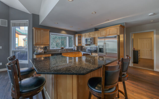 Kitchen area with modern appliances, cooking space, and windows.