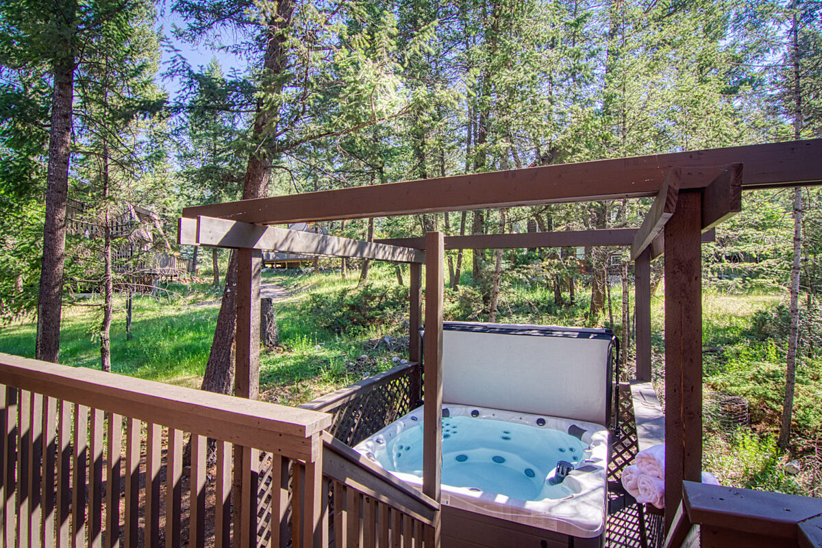 Hot tub with gazebo. Forest and trees in background.