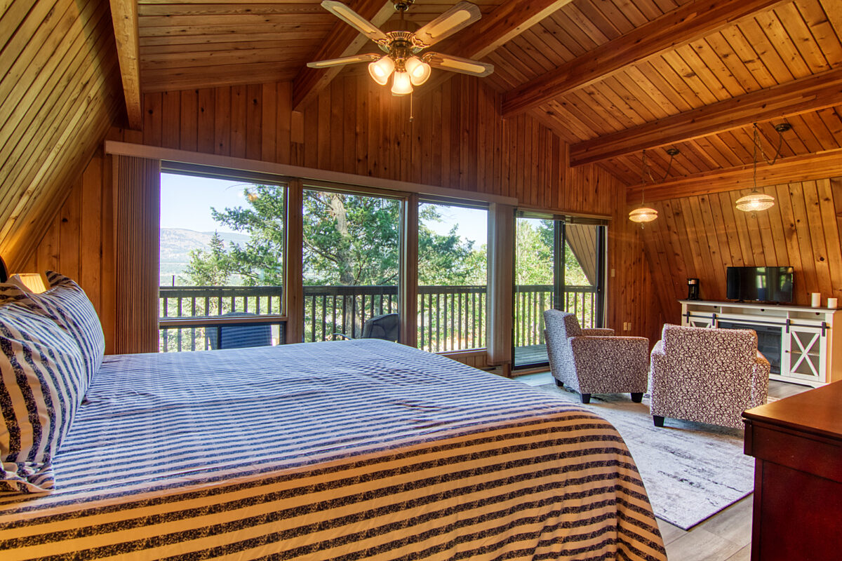 Bedroom with king bed, striped bedding, and ensuite patio.