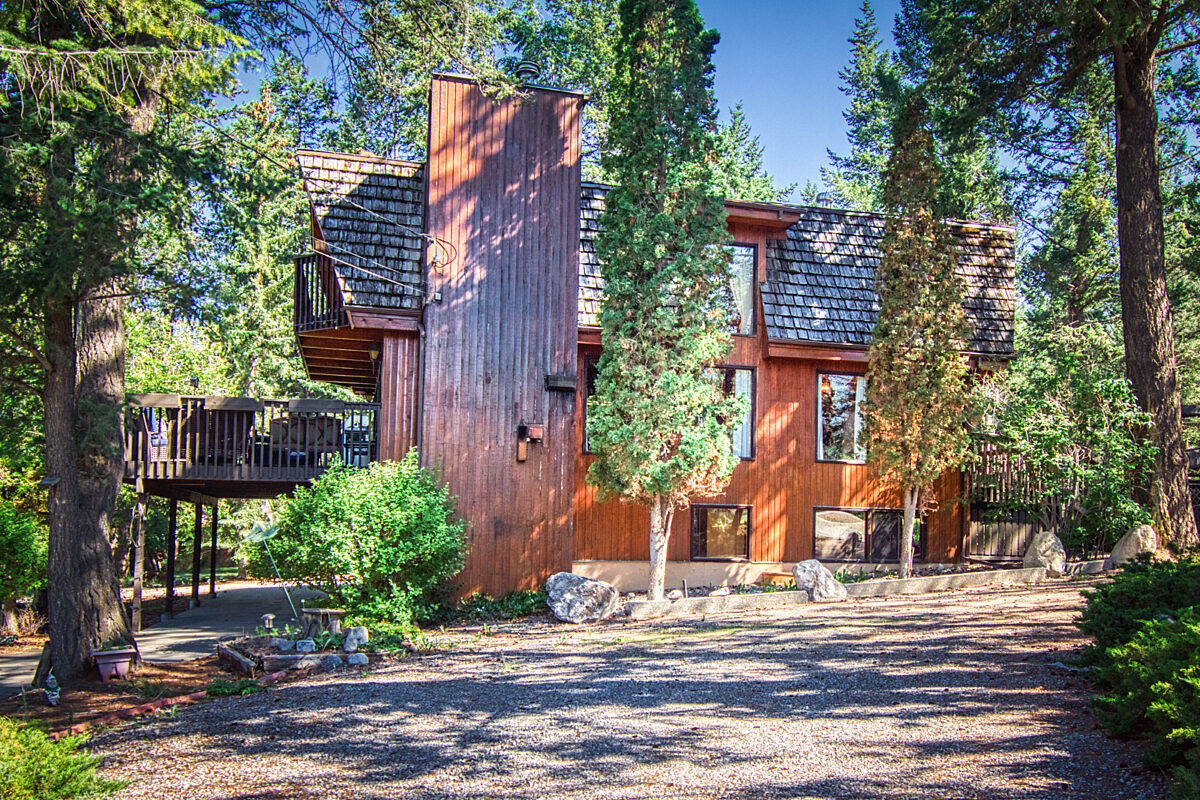 Wood panelled cabin surrounded by trees.