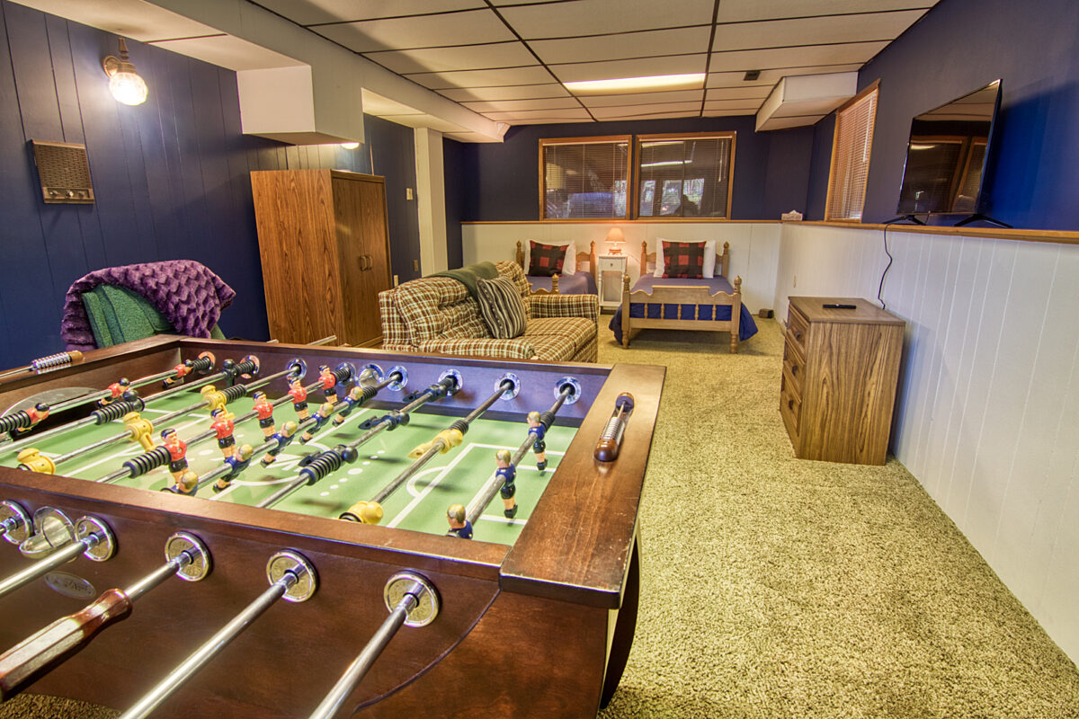 Foosball table and living room space with foosball table, couches, and TV.