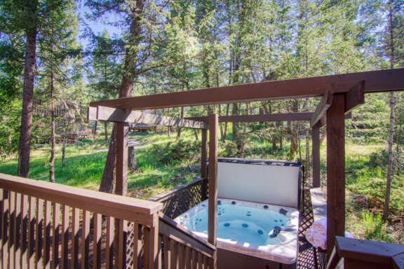 Hot tub with gazebo. Forest and trees in background.