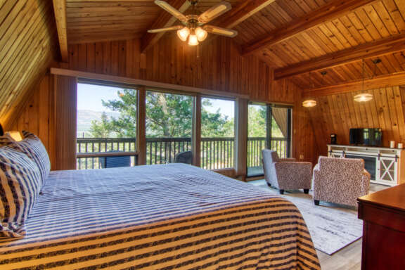 Bedroom with king bed, striped bedding, and ensuite patio.