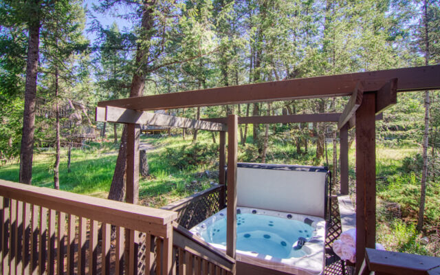 Wood panelled cabin surrounded by trees.
