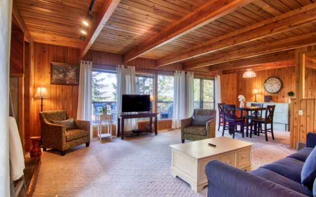 Wood panelled cabin surrounded by trees.