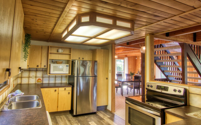Wood panelled cabin surrounded by trees.