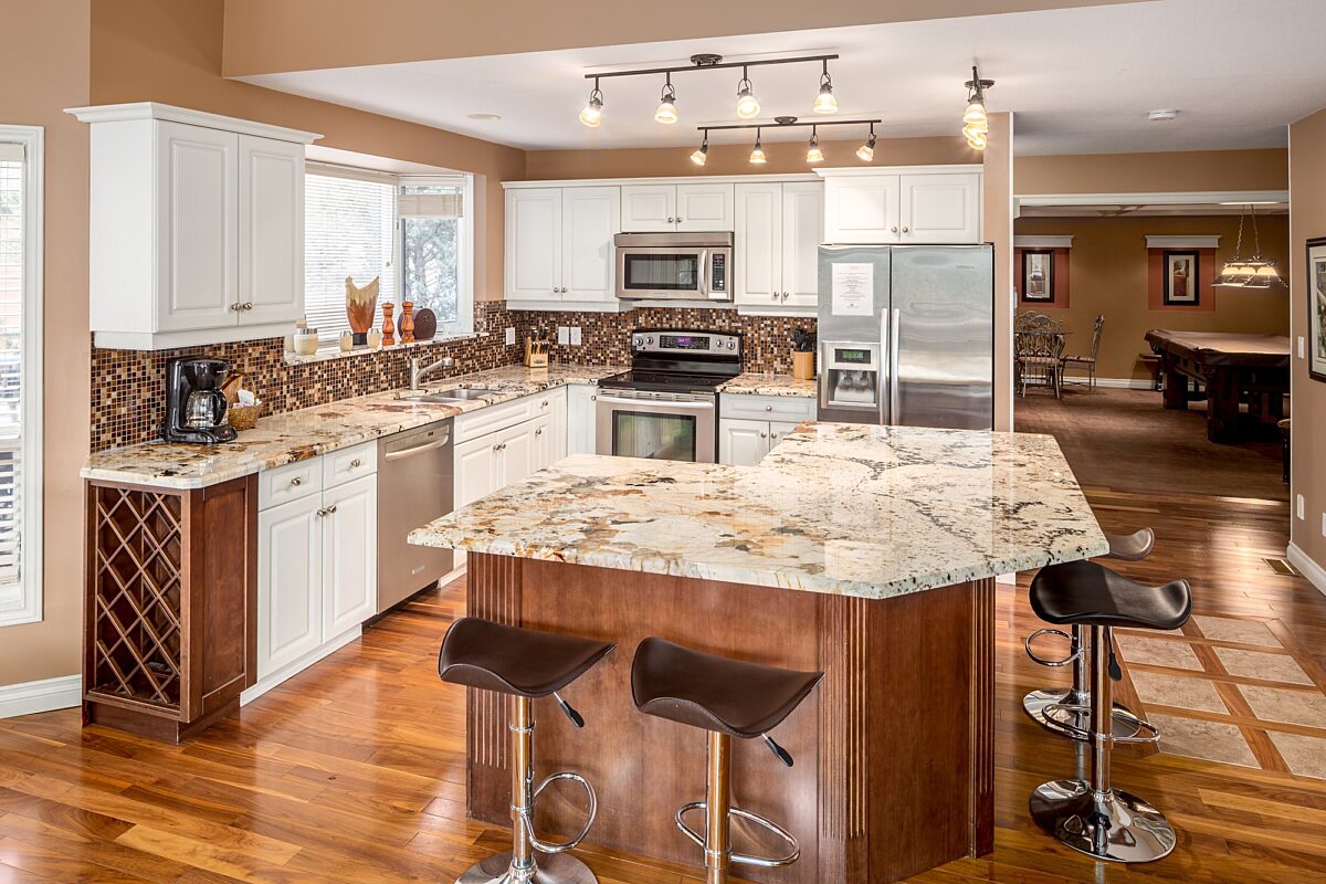 Spacious kitchen with island, barstools, appliances, and dining space to the rear.