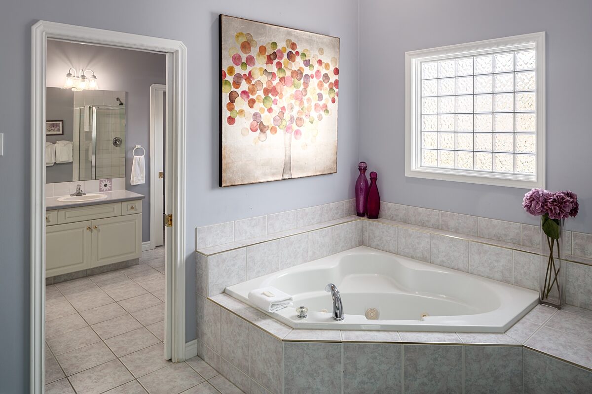 Master ensuite bathroom with jacuzzi, sink and vanity to the left.