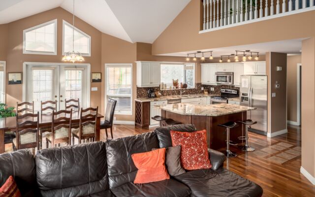 Spacious kitchen with island, barstools, appliances, and dining space to the rear.