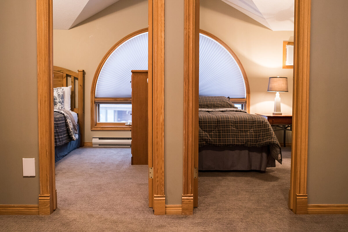 Two doors to bedrooms, one with two twin beds and one with one queen bed.