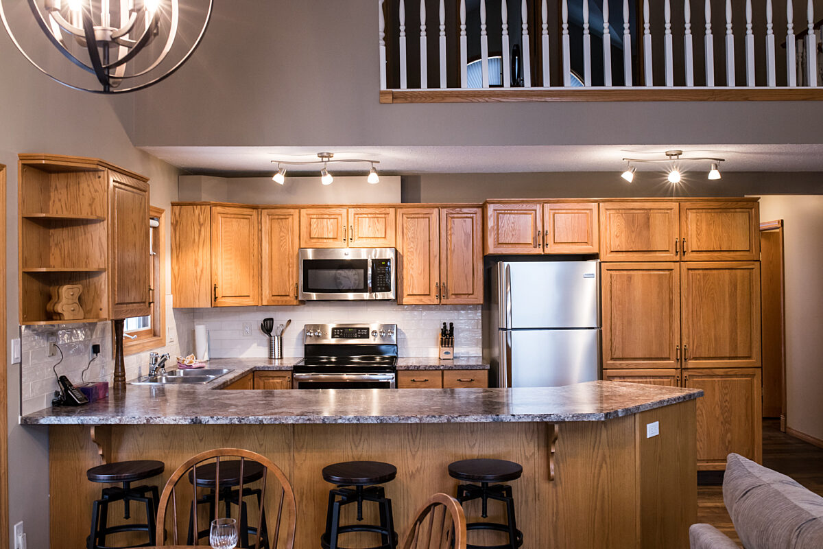 Spacious kitchen area with wooden cabinets, island counter-space, and stainless steel appliances.