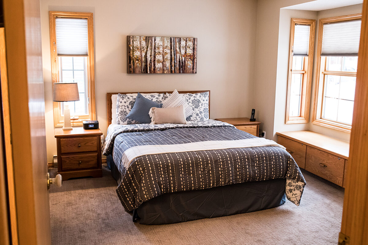 Master bedroom with queen bed, windows to either side of the bed.
