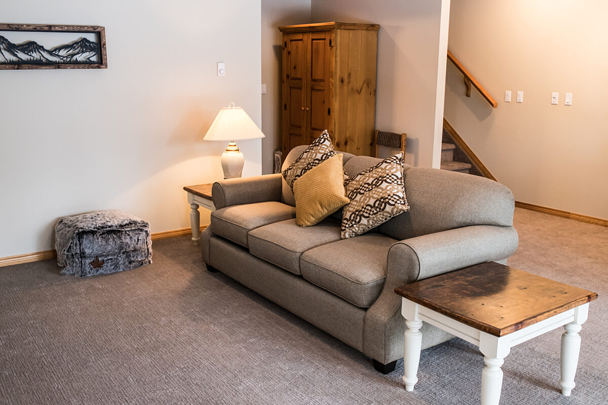 Living room area with couch and stairs to the rear.