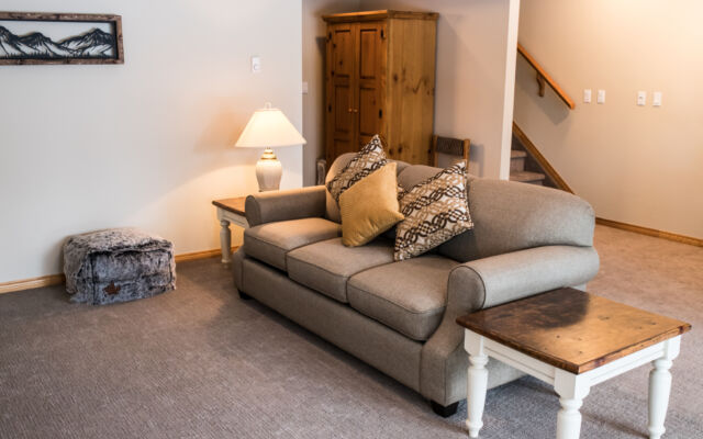 Living and dining areas as viewed from a loft above. Table and chairs, couch, and coffee table included.