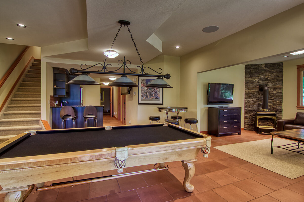 Living area with pool table, television, and fireplace.