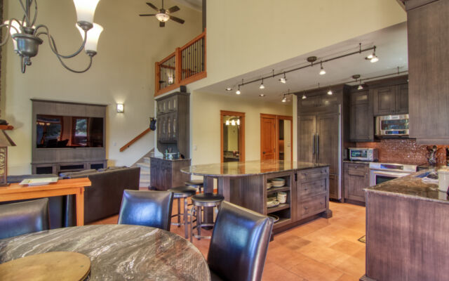 Wood paneled porch hot tub on a deck with its lid off. The water in the hot tub is clear. Porch overlooks treed area.