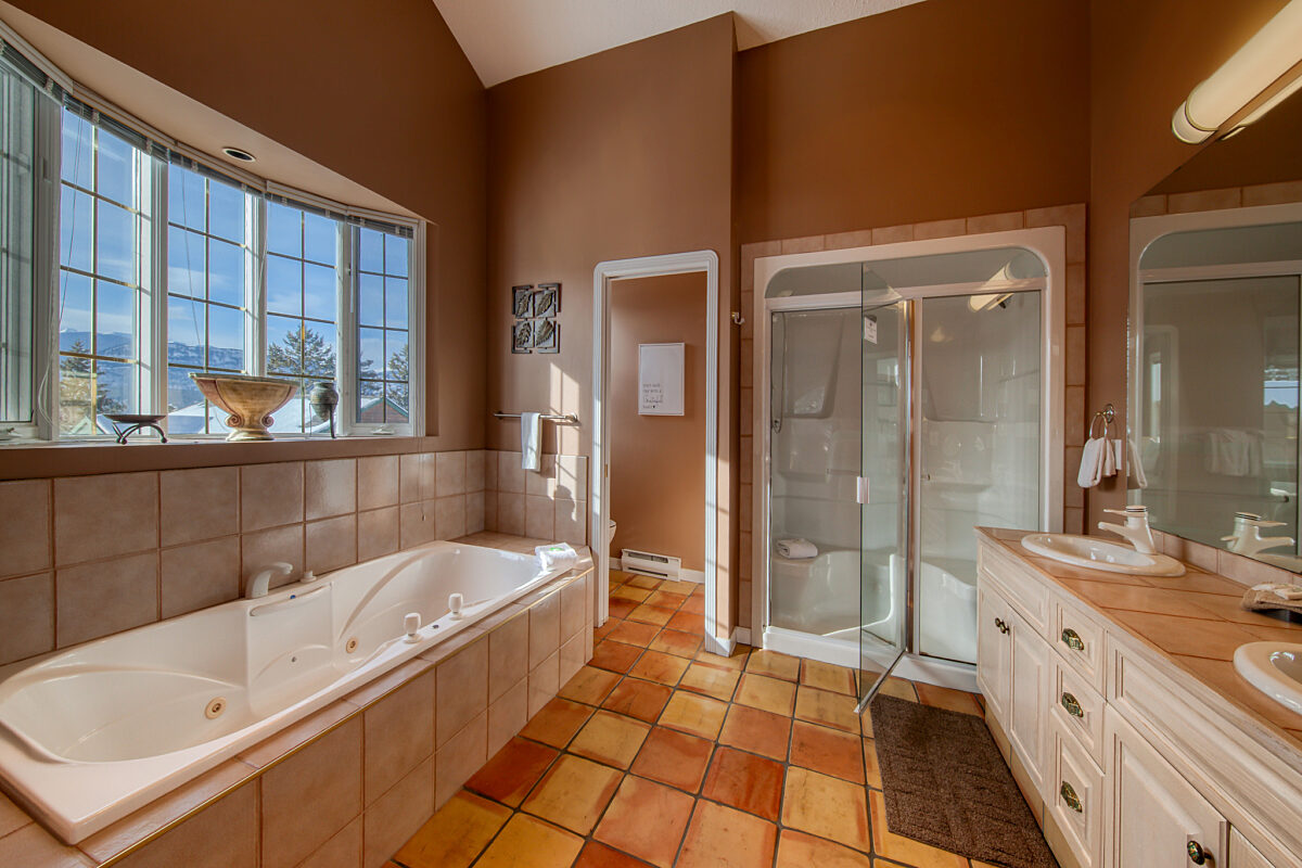Master bathroom with jacuzzi tub, shower, sink, and vanity