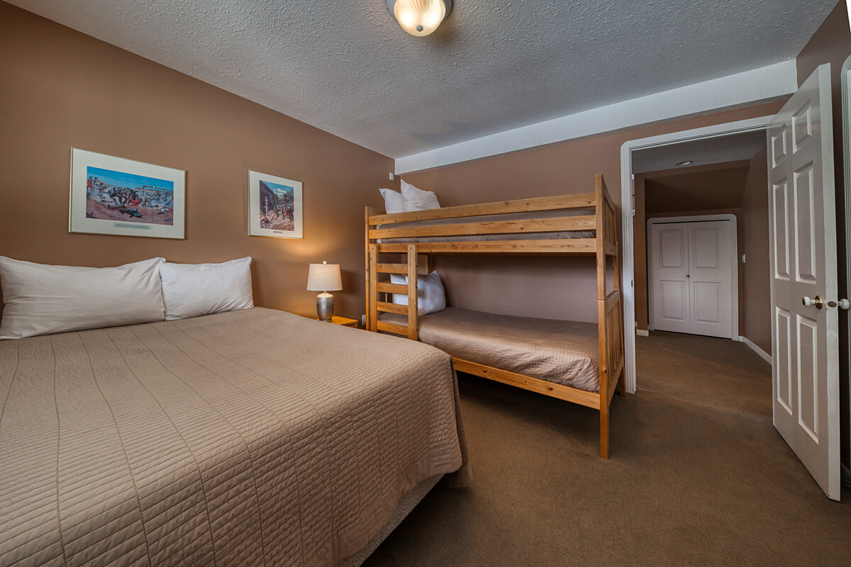 Lower level room with double bed and bunk bed.