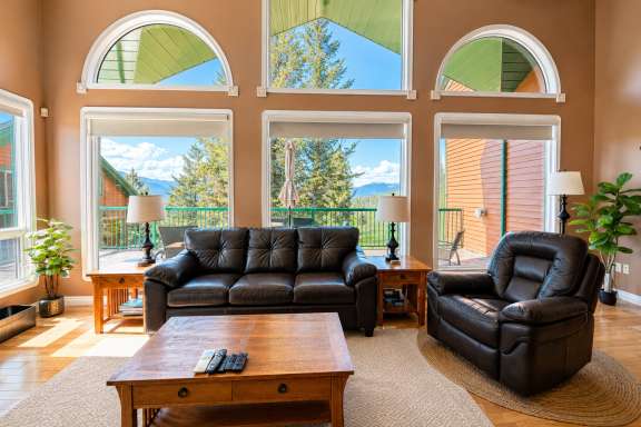 Living room at Marble Canyon 102 - Phase 1 with comfortable seating, floor-to-ceiling windows, air conditioning, and stunning valley and mountain views.
