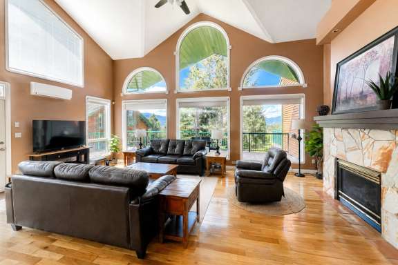Living room at Marble Canyon 102 - Phase 1 with comfortable seating, floor-to-ceiling windows, TV, air conditioning, and panoramic valley and mountain views.