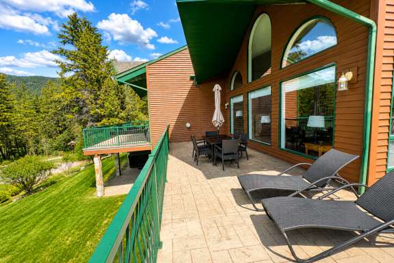 Wrap-around deck at Marble Canyon 102 - Phase 1 featuring outdoor dining, sun loungers, BBQ, and golf course and mountain views in Fairmont Hot Springs.