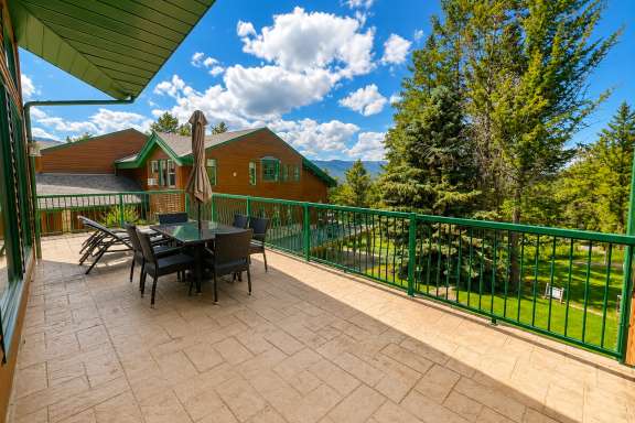 Outdoor dining area on the wrap-around deck at Marble Canyon 102 - Phase 1 with seating for six, additional chairs, and scenic valley and mountain views.