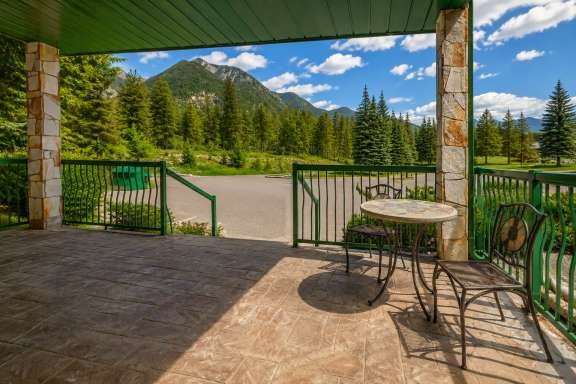 Front patio at Marble Canyon 102 - Phase 1 featuring a conversation table, seating for two, and scenic mountain views in Fairmont Hot Springs.