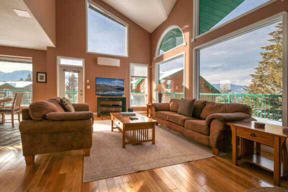 Living room with large picture windows. Two couches and a coffee table in the seating area.