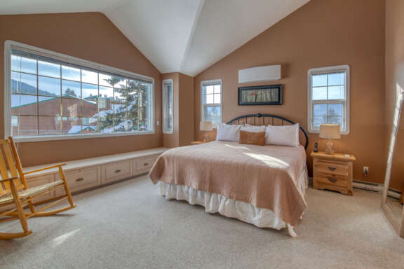 Master bedroom with king bed. Beige bedding and large window to the left.