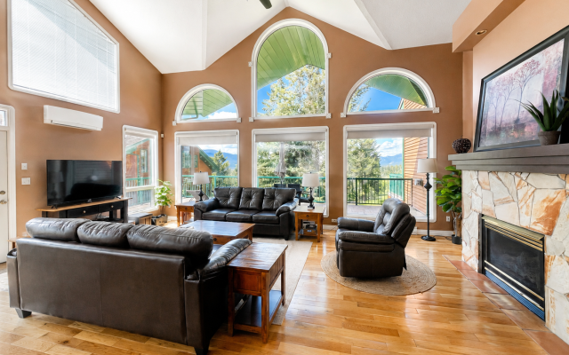 Dining area at Marble Canyon 102 - Phase 1 with seating for 8, floor-to-ceiling windows, open-concept living space and stunning golf course and mountain views.