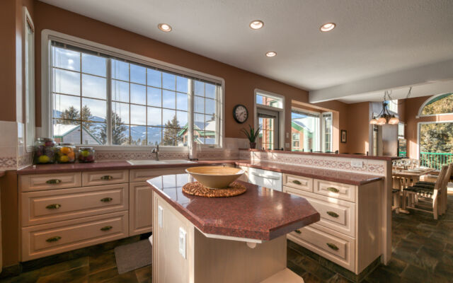 Dining area at Marble Canyon 102 - Phase 1 with seating for 8, floor-to-ceiling windows, open-concept living space and stunning golf course and mountain views.