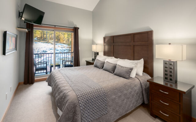 Living room with couches, fireplace, television, and large windows to the left.