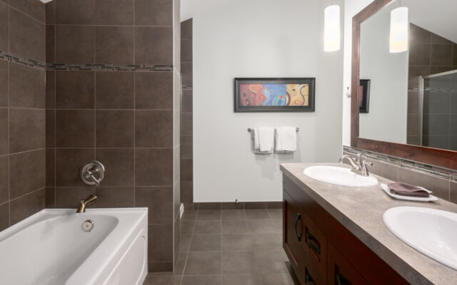 Living room with couches, fireplace, television, and large windows to the left.