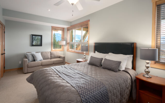 Living room with couches, fireplace, television, and large windows to the left.