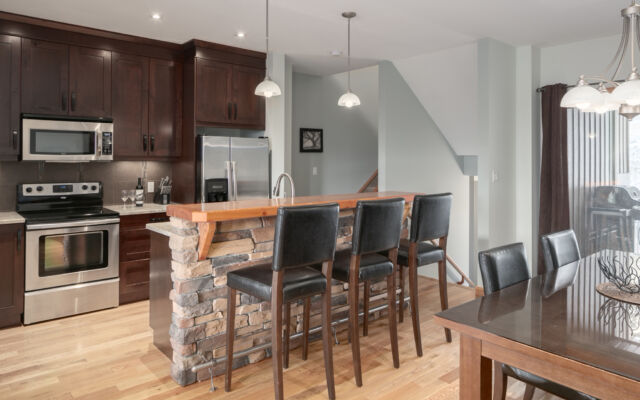 Living room with couches, fireplace, television, and large windows to the left.