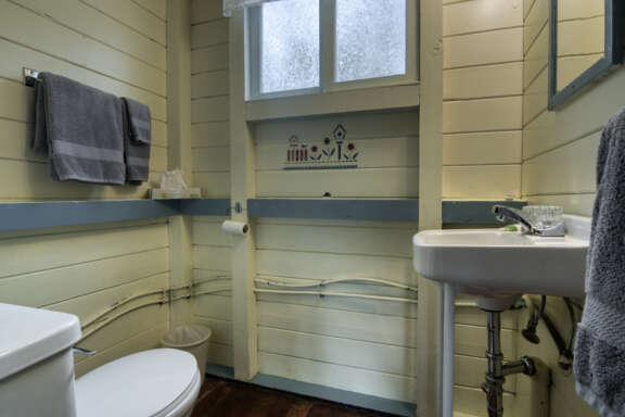 Bathroom area with toliet, sink, and vanity.