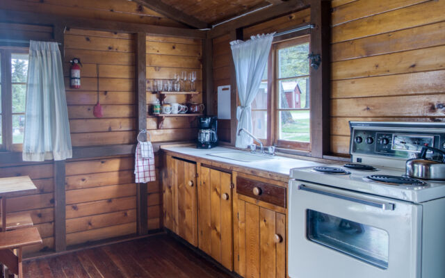 Outdoor living space with two red chairs and greenery.