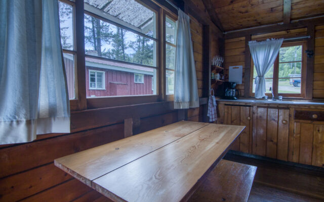 Outdoor living space with two red chairs and greenery.