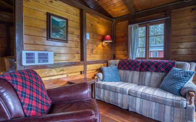 Outdoor living space with two red chairs and greenery.