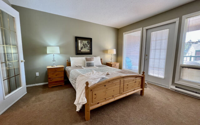 Living room with a brown velour couch, brown rug, fireplace, and coffee table.