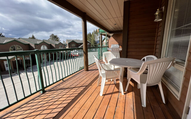 Living room with a brown velour couch, brown rug, fireplace, and coffee table.