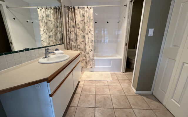 Living room with a brown velour couch, brown rug, fireplace, and coffee table.