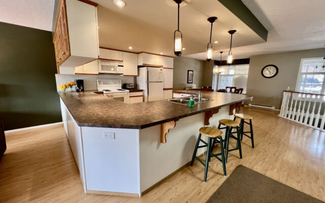 Living room with a brown velour couch, brown rug, fireplace, and coffee table.