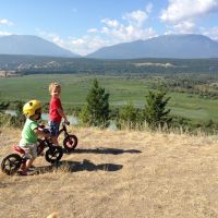 Children ride bikes on a dirt path