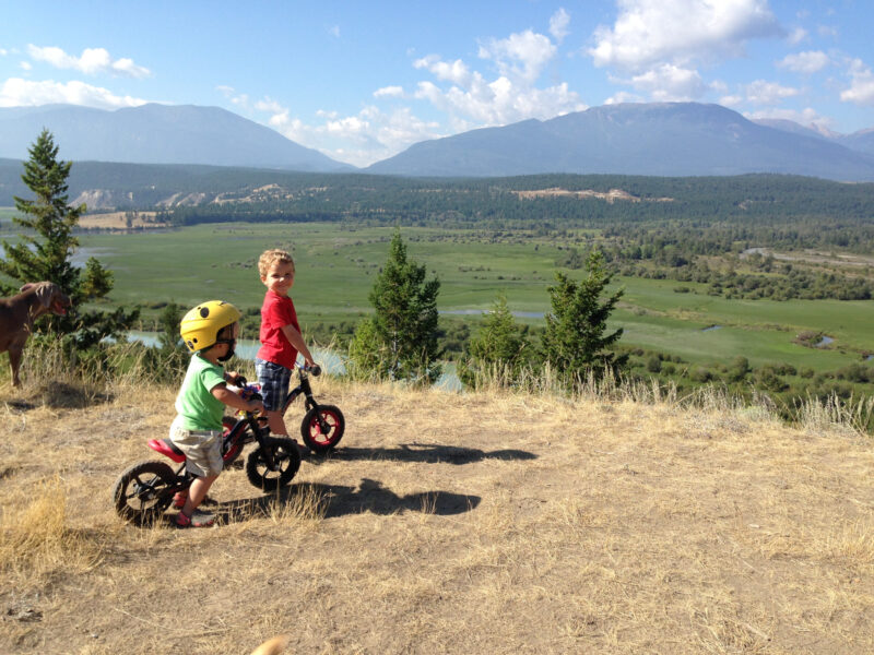 Children ride bikes on a dirt path