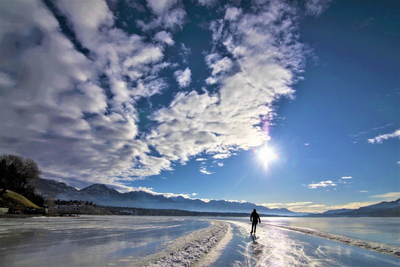 Skater enjoys skating the Lake Windermere Whiteway on a blue sky day