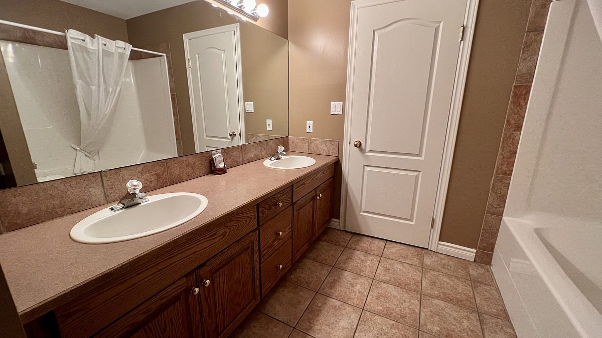 Bathroom area with vanity, shower, and sink in view