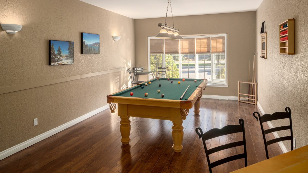 Recreation room with pool table and window to the rear.