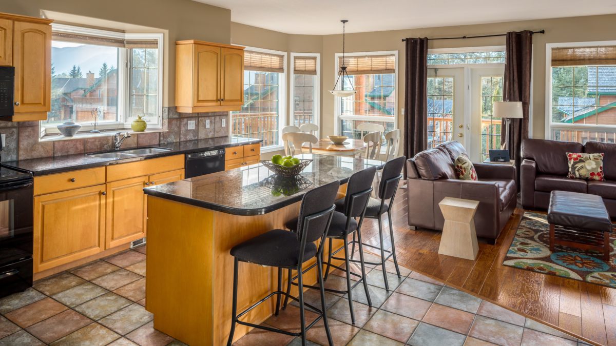 Spacious kitchen with island, barstools, and living space to the rear.